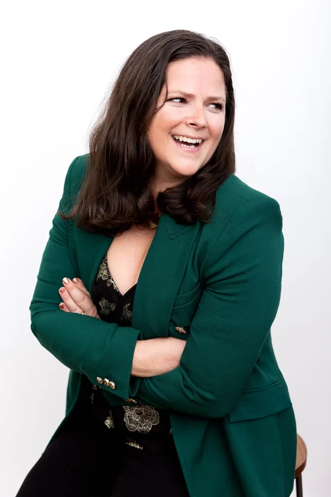 Tami in Green, smiling with arms crossed